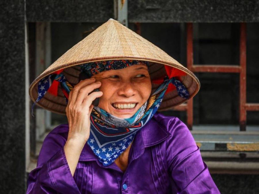 Vietnamese woman taking on moblie phone on street in Hanoi, Vietnam